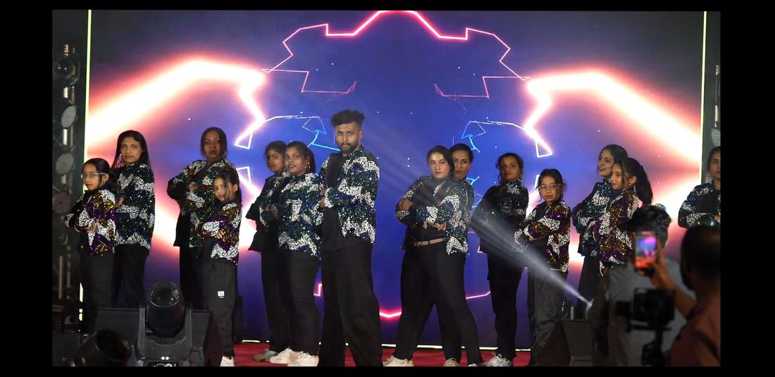 Dance crew posing on stage under dramatic lighting
