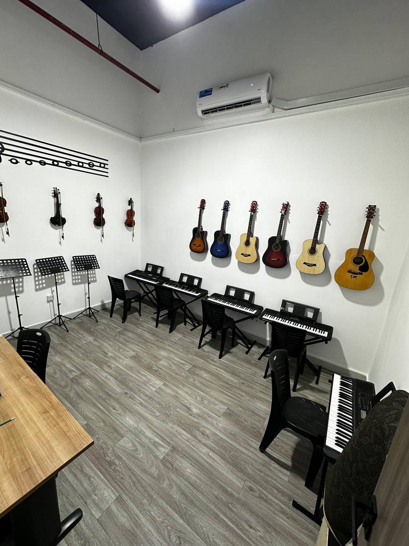 Wide view of the main practice room with guitars, violins, and keyboards