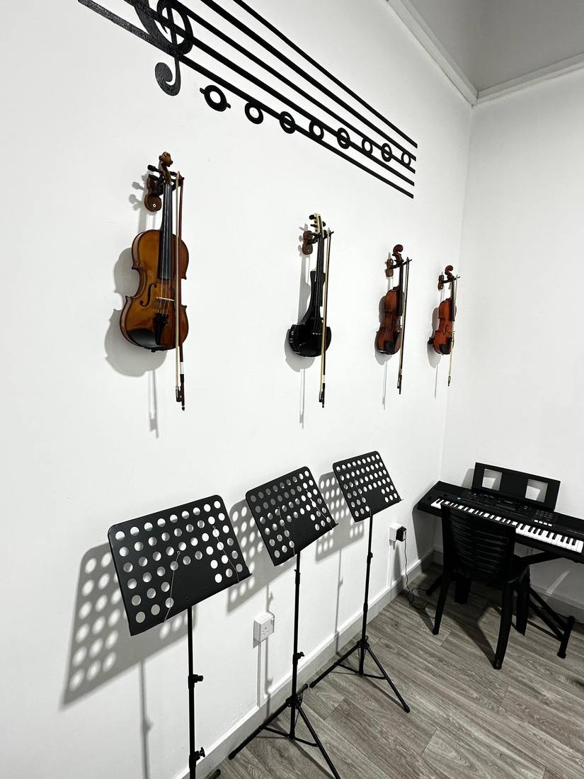 Violins mounted on the wall with a music-staff decal above